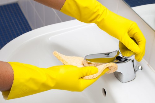 Cleaner preparing kitchen surfaces in a West London property